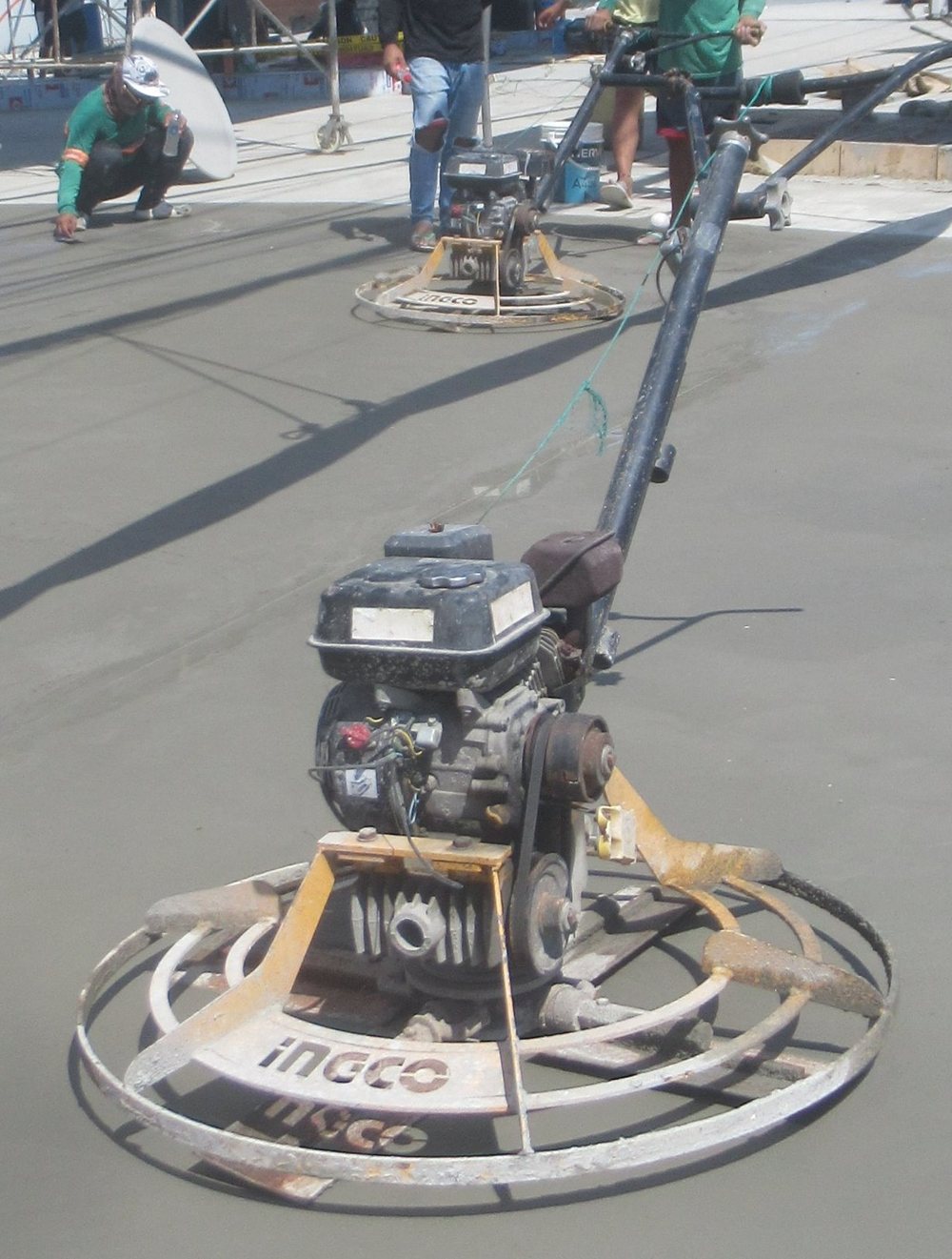 Power trowel finishing a fresh concrete slab